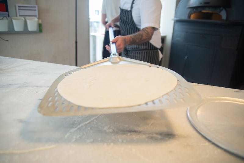Jet's pizza handcrafted pizza being prepared in our New York kitchen